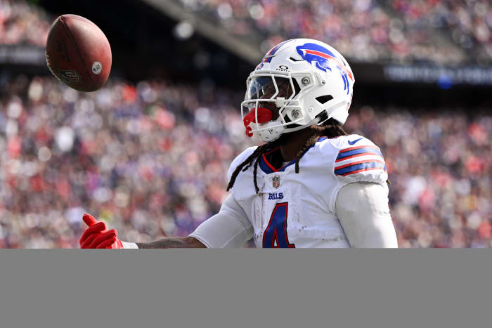 Buffalo Bills running back James Cook (4) tosses the ball after rushes against the New England Patriots during the first half at Gillette Stadium.
